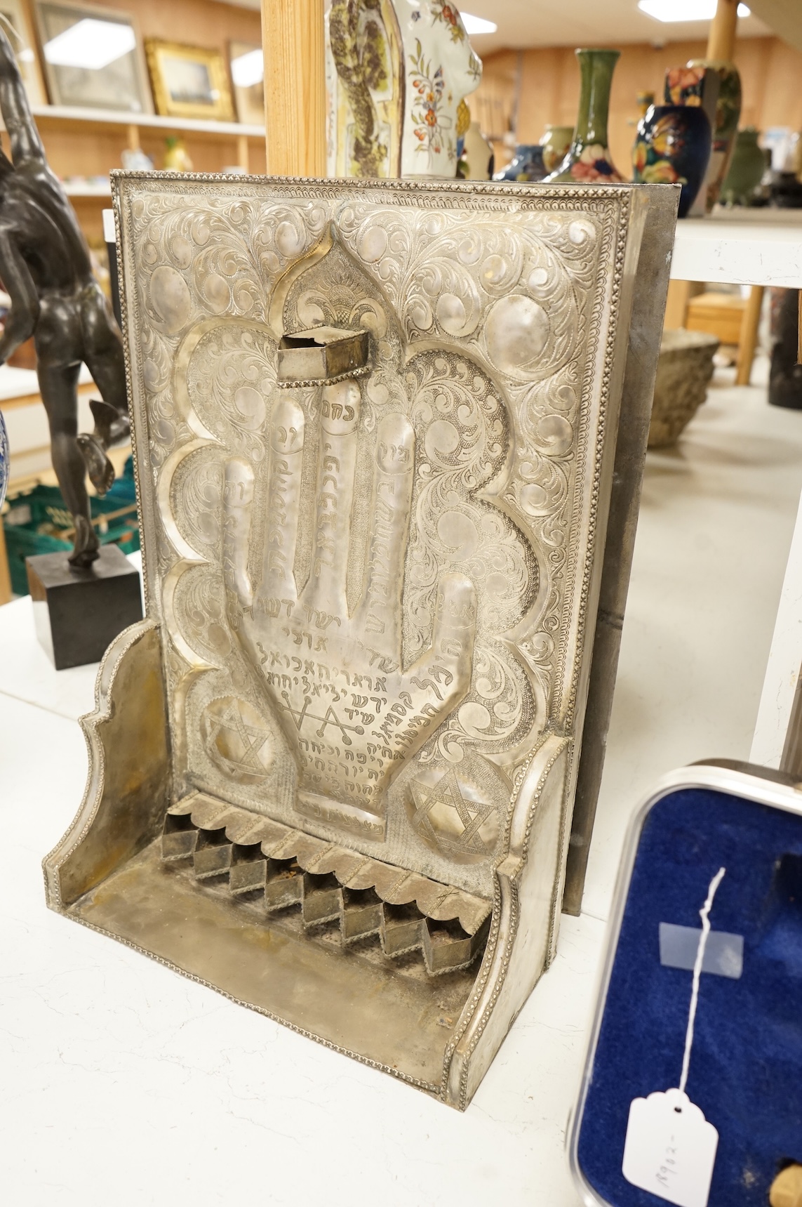 A Jewish embossed white metal menorah, 51cm high